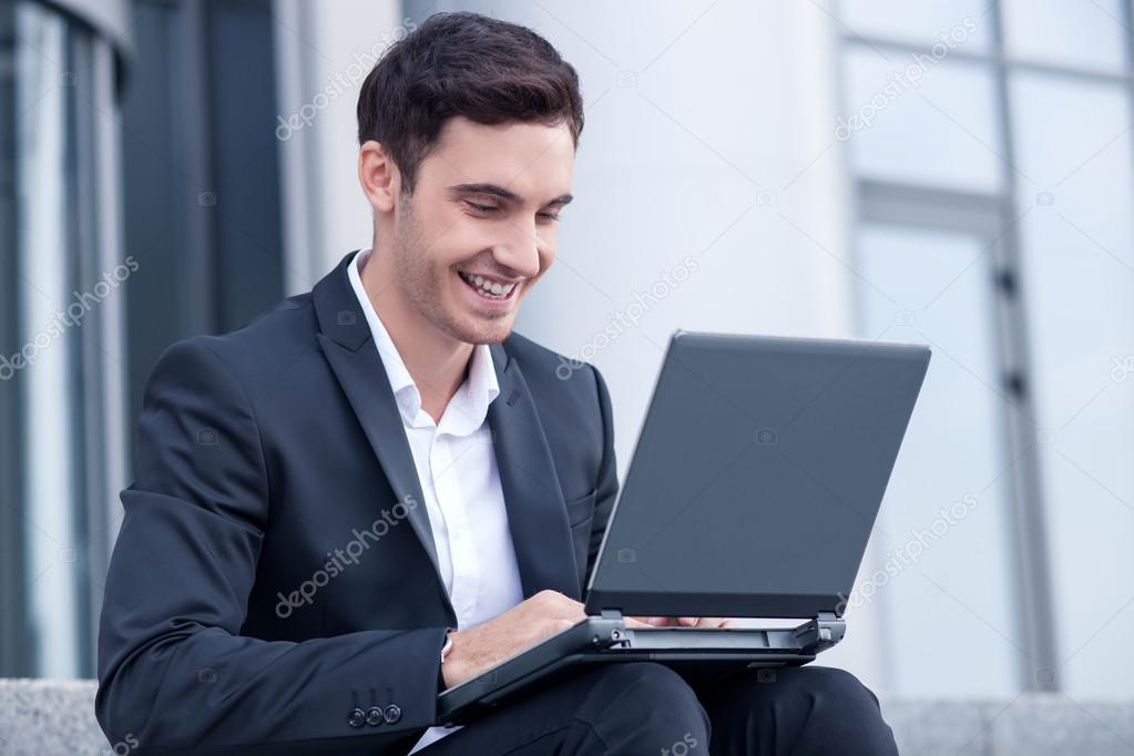 Attractive young man is using a laptop for work