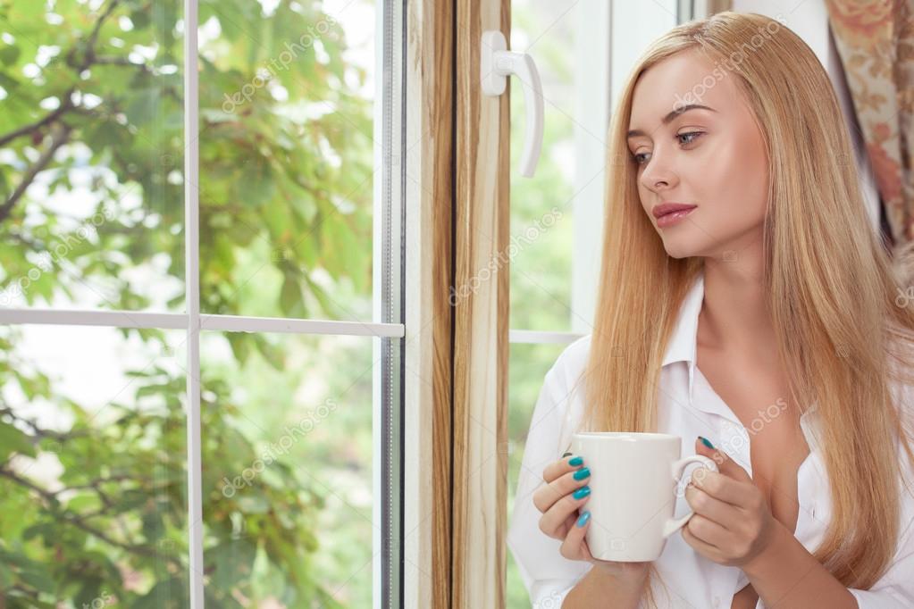 Attractive young girl is relaxing with hot drink