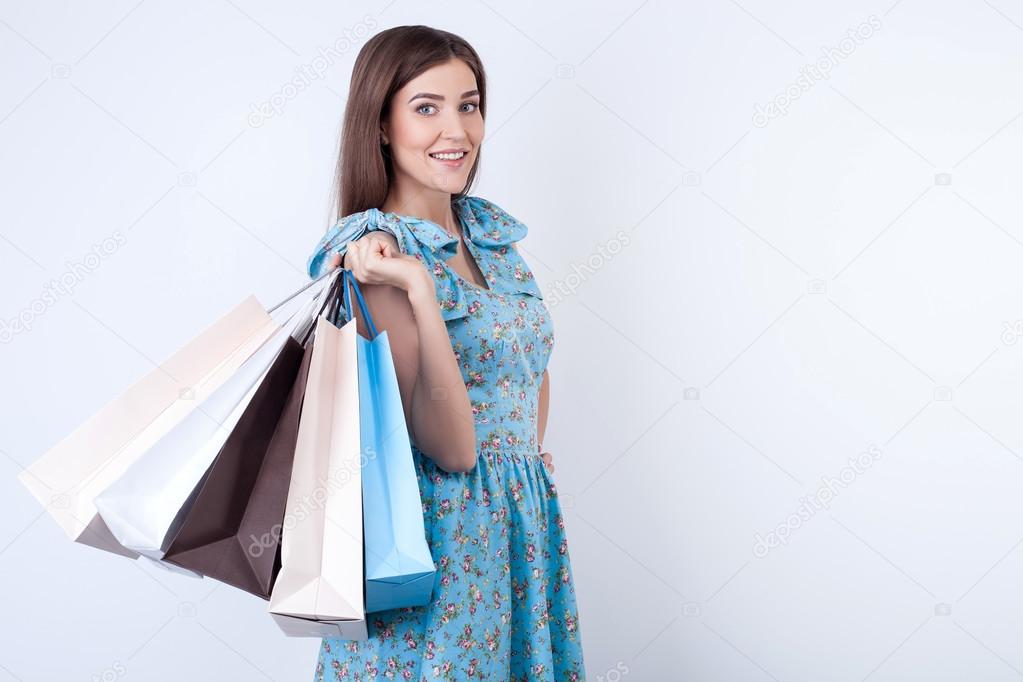 Beautiful young woman is buying clothing with joy