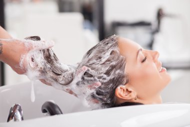 Pretty young girl is receiving hair treatment
