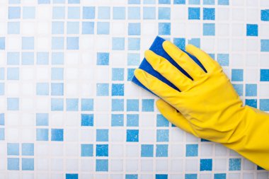 Skilled swabber is cleaning wall with a sponge