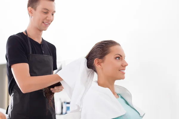 Handsome young male hairdresser is serving his customer — ストック写真