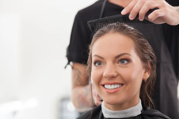 Jovem atraente está recebendo um corte de cabelo no salão — Fotografia de Stock