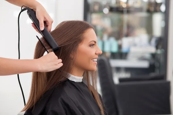 Experienced young hairstylist is serving her customer — Stok fotoğraf