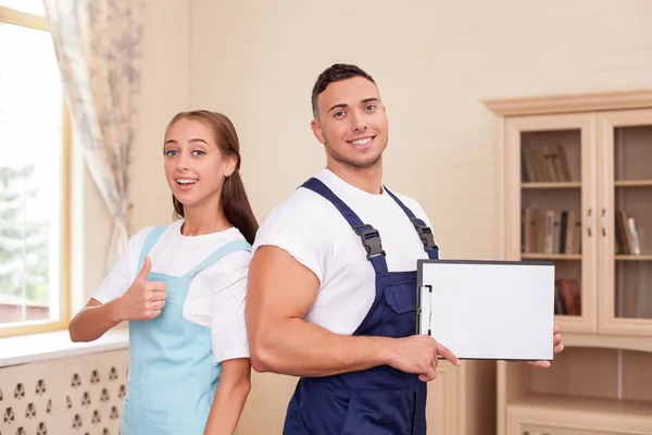 Attractive young workers in apron are cleaning the house — Stockfoto