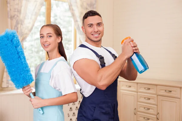 Bonito jovem casal está fazendo clean-up em casa — Fotografia de Stock