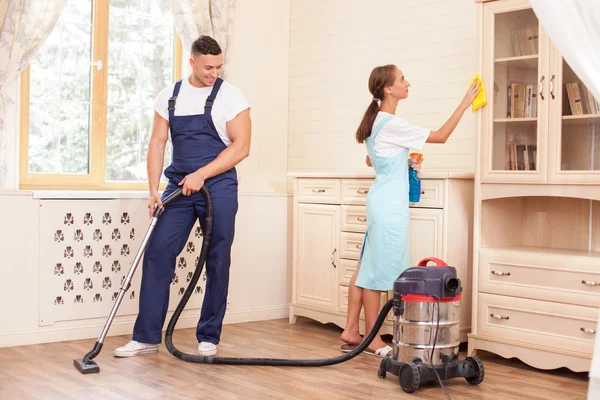 Cheerful young workers are cleaning the house with joy — Stok fotoğraf