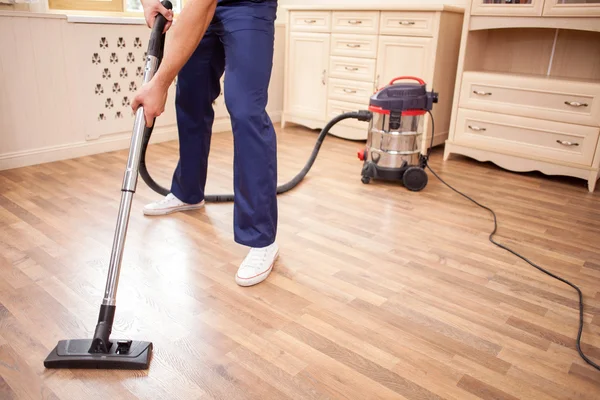 Cheerful young cleaner is doing housework with joy — 图库照片