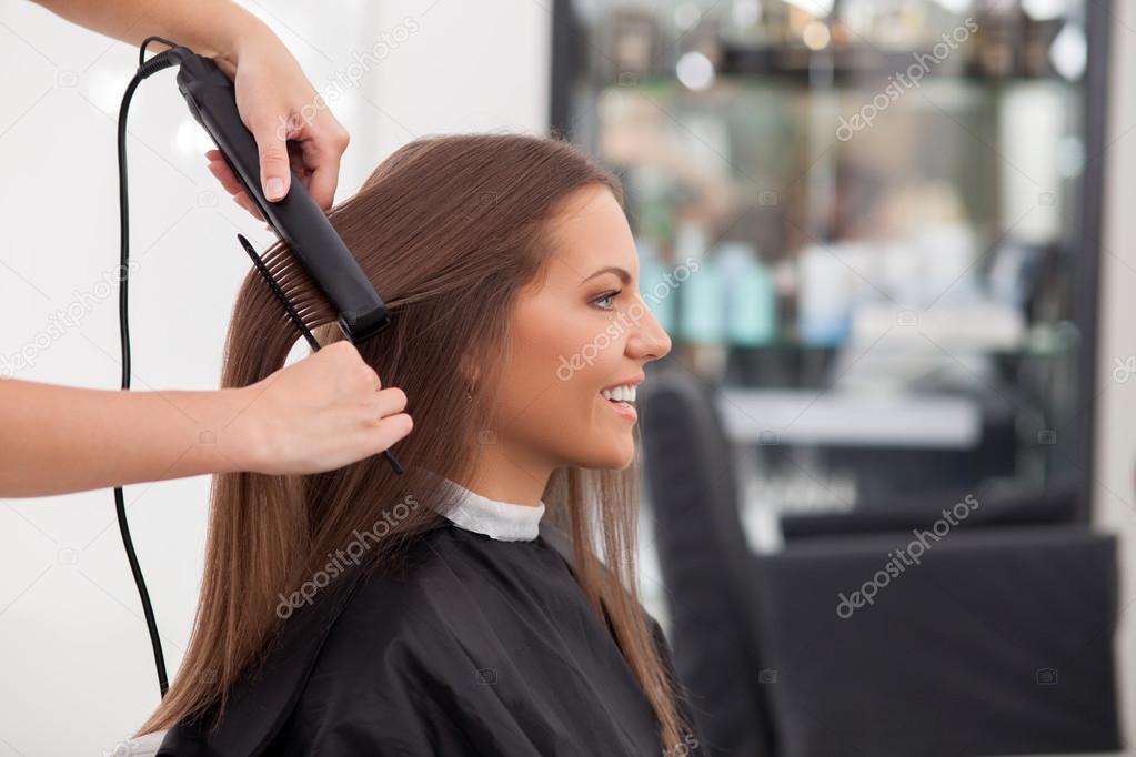 Experienced young hairstylist is serving her customer