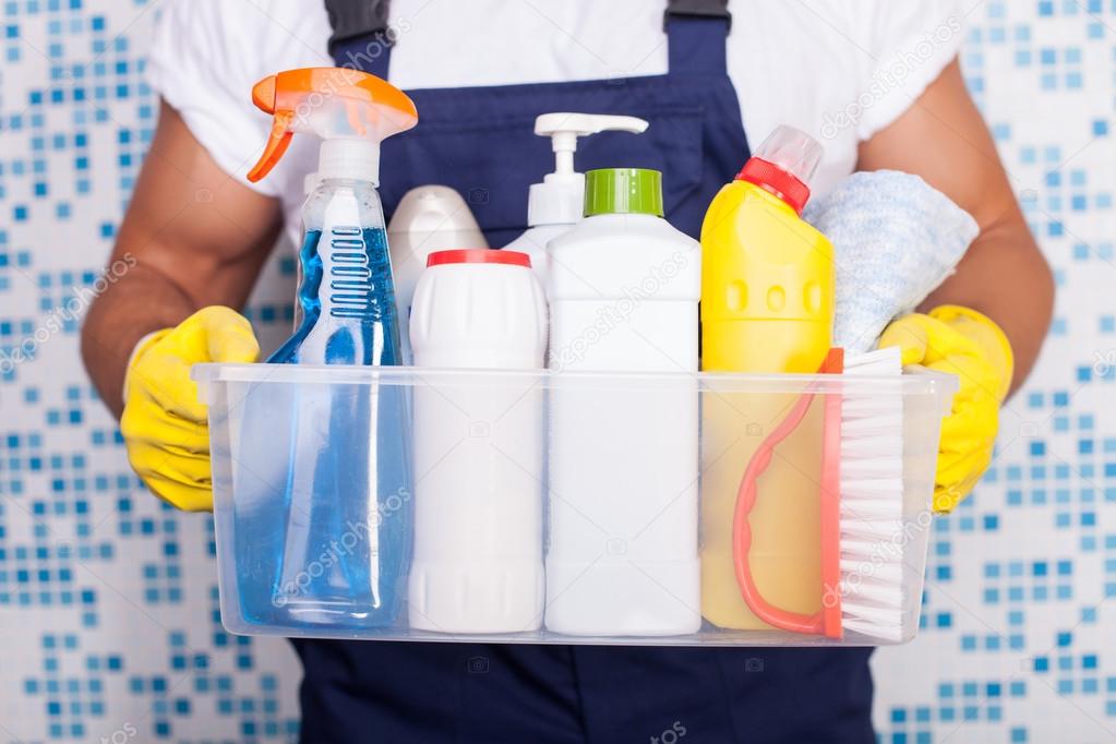 Cheerful young cleaner is presenting his equipment