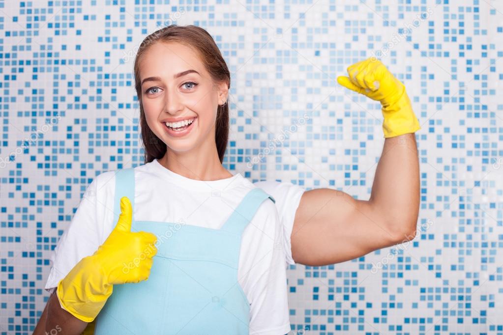 Cheerful young housewife is expressing her strength