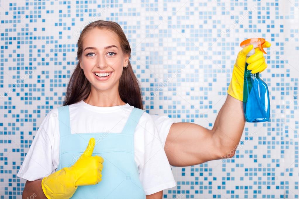 Beautiful young female cleaner is doing cleanup Stock Photo by