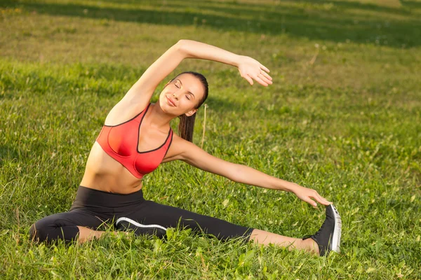 Cheerful young woman is exercising in a park — Φωτογραφία Αρχείου