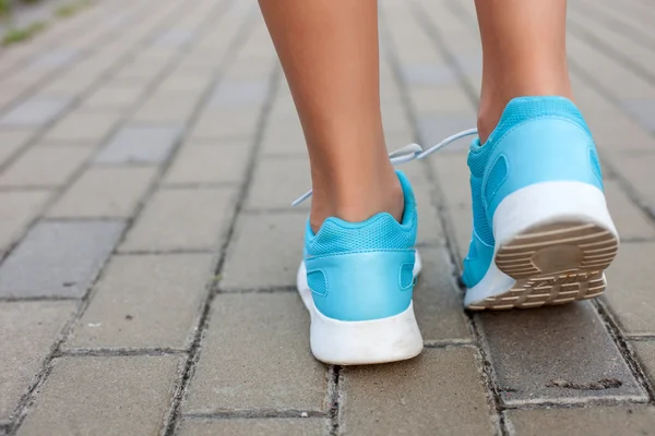 Pretty young sportswoman is walking along the road — Stock Photo, Image