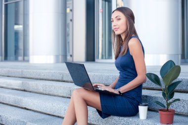 Beautiful young woman is working with a notebook