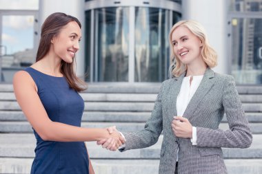 Cheerful young women are congratulating each other