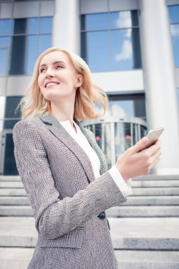 Cheerful young woman is using telephone for communication