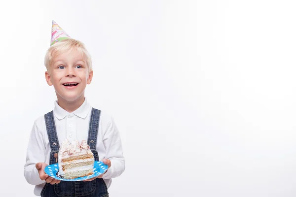 Alegre niño masculino está comiendo comida dulce en la celebración — Foto de Stock