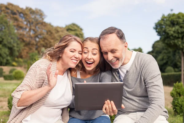 Beautiful girl is showing tablet to her old parents — 图库照片