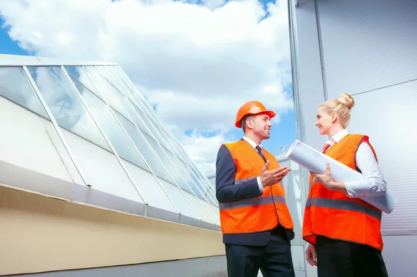 Alegre jóvenes ingenieros están discutiendo un plan de construcción — Foto de Stock