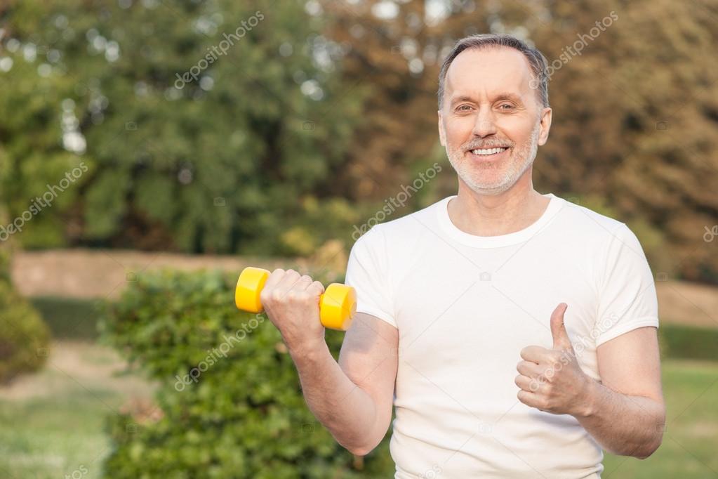 Pretty old man is exercising with joy