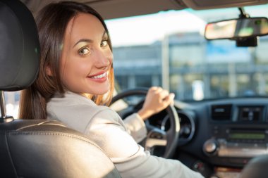 Attractive young female driver is traveling with joy