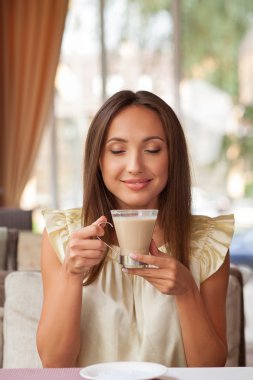 Cheerful young woman is resting in cafe