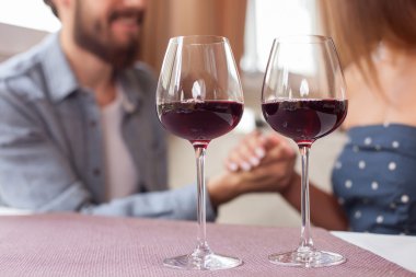 Pretty young loving couple is dating in restaurant