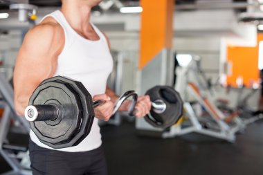 Attractive young sportsman is training in fitness center