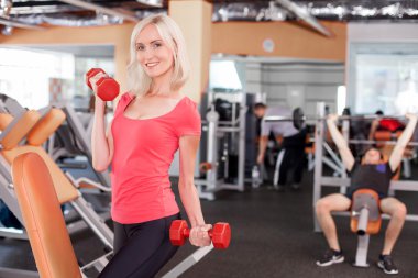 Attractive young female athlete is training in gym