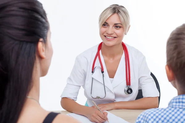 Cheerful young female doctor is treating child — Stock Photo, Image