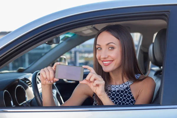 Beautiful female driver is making photos on telephone — Stock Photo, Image