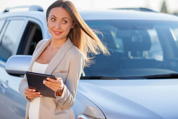 Attractive young woman is using laptop near transport — Stock Photo, Image