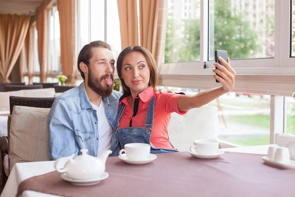 Casal atraente casal está fotografando-se na cafetaria — Fotografia de Stock