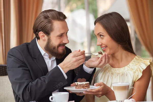 Cheerful young loving couple is dating in restaurant — Stockfoto