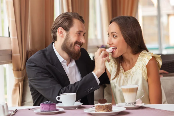 Beautiful loving couple is eating in restaurant — Stock Photo, Image