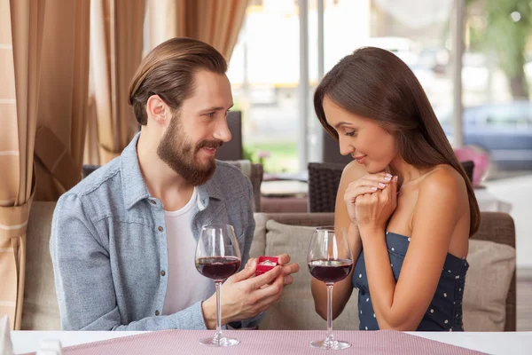 Cheerful young loving couple is celebrating in cafe — Stock Photo, Image