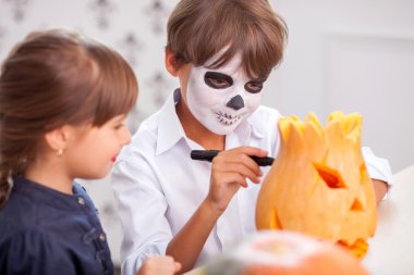 Pretty children are decorating gourd for celebration