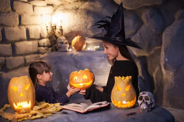 Atraente jovem feiticeira está ensinando sua filha — Fotografia de Stock
