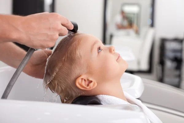 Pretty healthy boy is getting hairwash in beauty shop — Stock fotografie