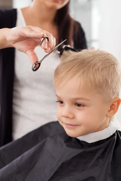 Experienced young female barber is serving child — Zdjęcie stockowe