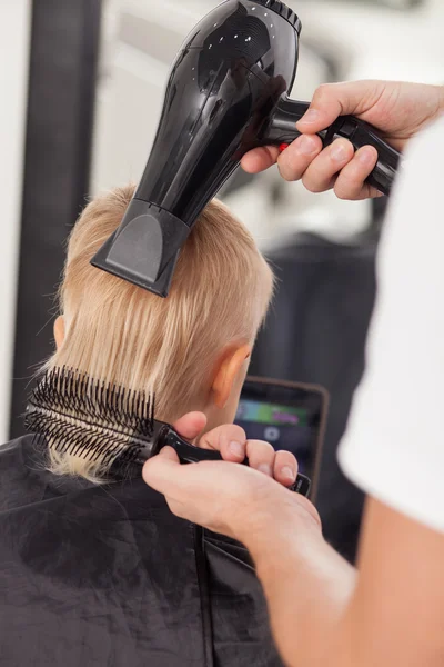 Skilled young barber is working in hairdressing salon — Zdjęcie stockowe