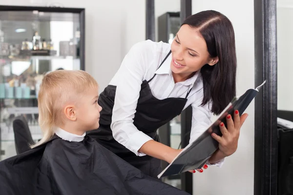 Beautiful young female hairstylist is serving her client — ストック写真