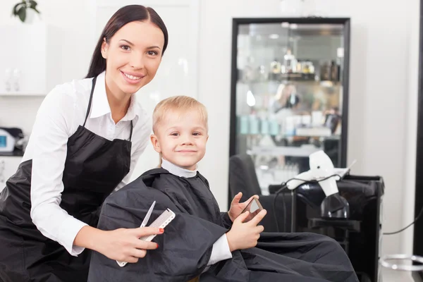 Cheerful young female hairstylist is working in salon — 스톡 사진