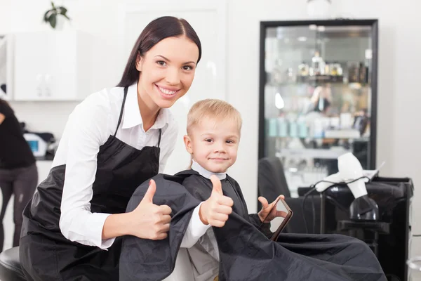 Beautiful young female barber is working in salon — Zdjęcie stockowe