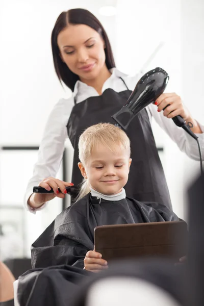 Attractive young hairstylist is working in beauty salon — Stockfoto