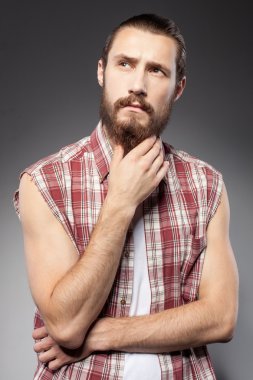 Attractive young bearded hipster guy is pensive