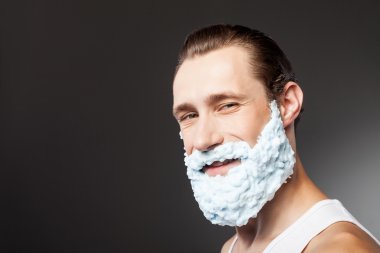 Attractive bearded young hipster guy is ready to shave