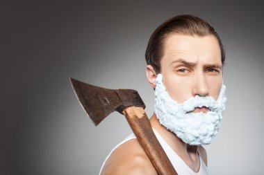 Handsome young hipster guy with beard and hatchet