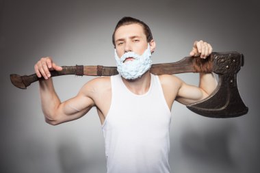 Attractive young hipster man is boasting of his hatchet